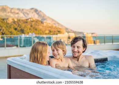 Portrait of young carefree happy smiling happy family relaxing at hot tub during enjoying happy traveling moment vacation. Life against the background of green big mountains - Shutterstock ID 2105559638