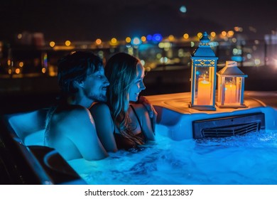 Portrait of young carefree happy smiling couple relaxing at hot tub during enjoying happy traveling moment vacation life against the background of green big mountains at night - Shutterstock ID 2213123837