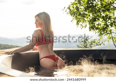 Portrait of young carefree happy smiling girl traveler relaxing at hot tube during enjoying happy traveling moment vacation life against the background of mountains