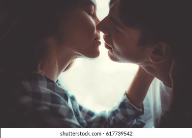 Portrait of young caucasian couple kissing. Close up.
