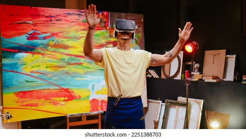 Portrait of young Caucasian creative talented man artist stands in art studio wearing virtual reality glasses moving hands in air creating new project, innovative technology, VR headset, art concept - Powered by Shutterstock