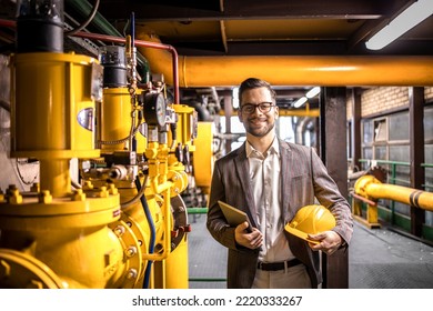 Portrait of young caucasian factory manager standing by gas pipeline inside refinery plant. - Shutterstock ID 2220333267