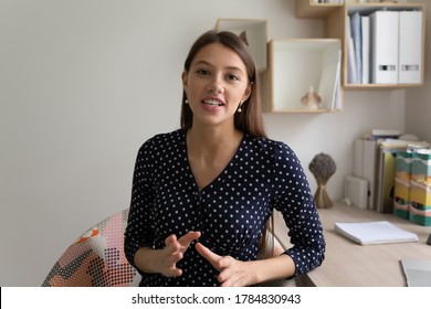 Portrait of young Caucasian female coach or blogger talk on video cam, have online webcam conversation, millennial woman speaker influencer speak on virtual event call or conversation at home