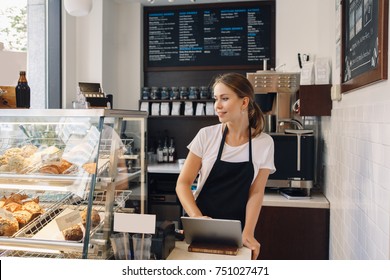 Portrait Of Young Caucasian Female Woman Cashier. Seller Using Touch Pad For Accepting Client Customer Payment. Small Business Of Coffee Shop Cafeteria.