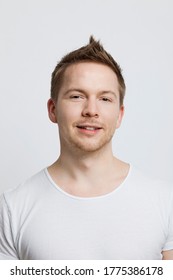 Portrait Of Young Caucasian Man With Spiked Hair Against White Background