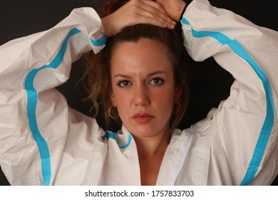 Portrait Of A Young Caucasian Nurse Wearing A Personal Protective Equipment. She Is Holding Her Hair Getting Ready To Work