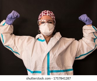 Portrait Of A Young Caucasian Nurse Wearing A Personal Protective Equipment And Raising Her Arms. Concept Of Strong, We Can Do It And Brave.