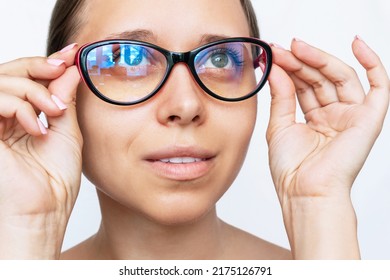 Portrait Of A Young Caucasian Woman With Red And Black Female Glasses For Working At A Computer With A Blue Filter Lenses Isolated On A White Background. Anti Blue Light And Rays. Eye Protection