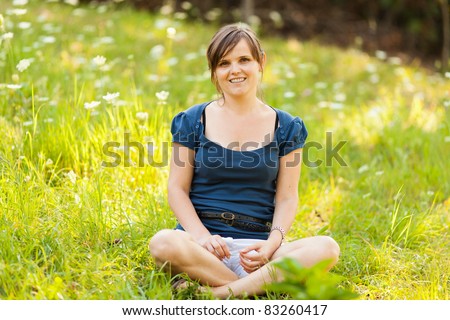 Portrait of a young caucasian woman relaxing outdoor in a meadow