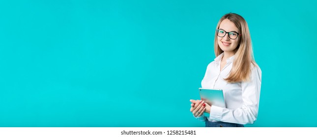 Portrait Young Caucasian Woman Worker Teacher Trainer Mentoring In White Shirt Office Style Long Hair With A Tablet In Hand Uses Technology Isolated Bright Color Blue Background.