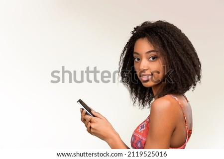 Similar – Serious black woman with afro hair looking at her smart phone outdoors.