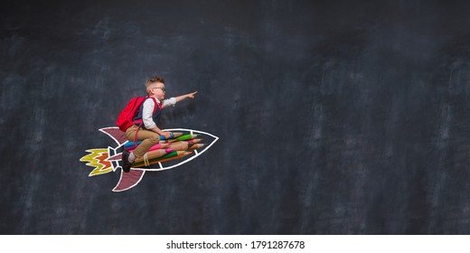 Portrait of young child sitting on rocket with bag. Kid playing at home. Child flying on drawn rocket in education space. Imagination, idea and creative. Copy space for your text. winner and leader