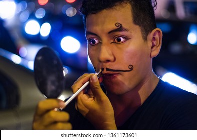 Portrait Of A Young Clown Putting On Mustaches With Makeup.