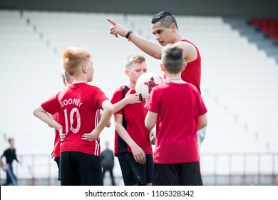 Portrait of young coach giving instruction tp group of boys motivating them during football match, copy space - Powered by Shutterstock