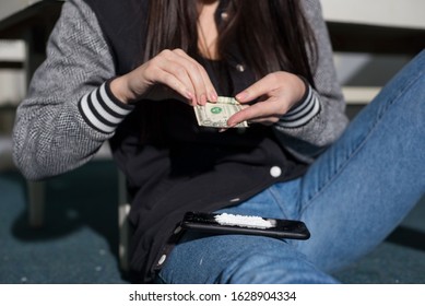 Portrait Of A Young Cocaine Girl Using Coca Powder And A Straw From A Dollar. The Problem Of Drug Use In Women.