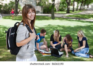 Portrait Of Young College Girl At College Campus With Classmates Studying In Background