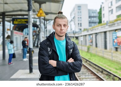 Portrait of young confident guy at railway station of electric city train - Shutterstock ID 2361426287