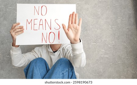 Portrait of a young confident woman holding a banner saying "no means no", symbolizing empowerment, women's rights and protection. Awareness of gender-based violence