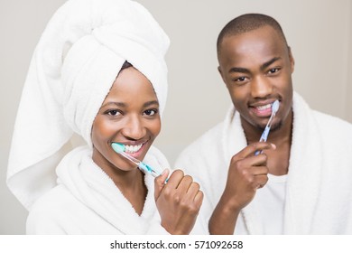 Portrait of young couple brushing teeth in the bathroom