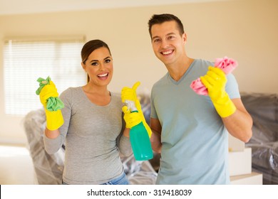 Portrait Of Young Couple Cleaning Their New House