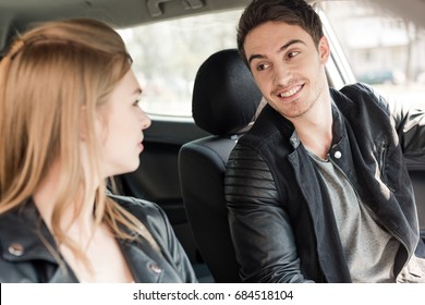 Portrait Of Young Couple Looking At Each Other While Riding Car