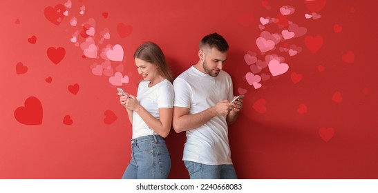 Portrait of young couple with mobile phones chatting online on red background. Valentine's Day celebration - Powered by Shutterstock