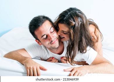 Portrait Of Young Couple With Playful Behavior In Bedroom.