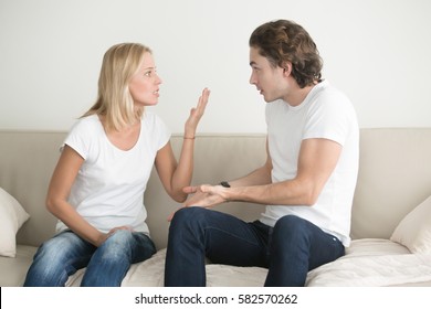 Portrait of young couple quarrelling, woman is blaming man, consistent verbal fighting. Family problems concept  - Shutterstock ID 582570262