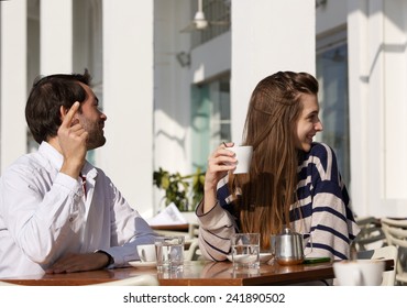 Portrait Of A Young Couple Sitting At Outdoor Cafe Asking For The Bill