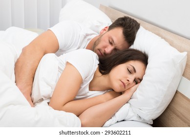 Portrait Of Young Couple Sleeping On Bed