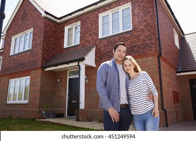 Portrait Of Young Couple Standing Outside New Home