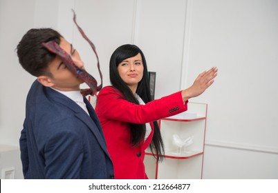 Portrait of young crying  business woman in red jacket  giving a slap in the face to her flirting colleague in office, relationship at work concept