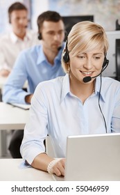 Portrait Of Young Customer Service Operator Talking On Headset, Smiling.