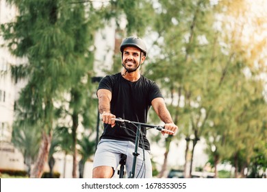 Portrait Of Young Cyclist On His Bicycle Wearing Helmet Outdoors