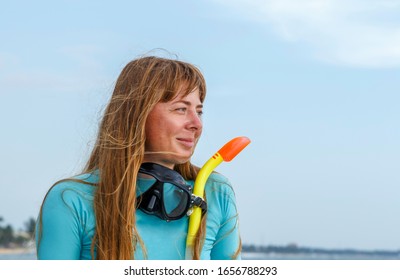 Portrait Of Young Diver Girl With A Snorkel And Mask Against The Sky And Sea