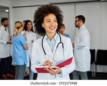 portrait of a young doctor or physician in the front of her team