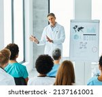 Portrait of a young doctor teaching on a seminar in a board room or during an educational class at convention center 