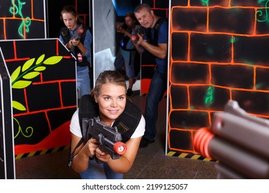 Portrait Of Young Emotional Woman With Laser Gun Having Fun With Family On Lasertag Arena