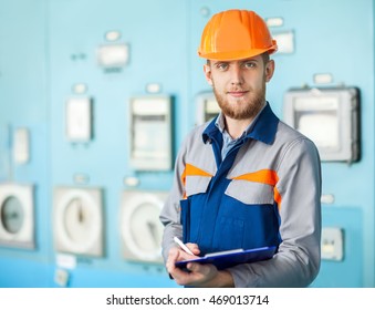 Portrait of young engineer taking notes at control room in factory - Powered by Shutterstock