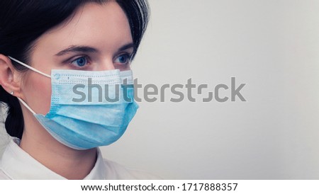 Portrait of a young European woman in a protective disposable medical mask. Concept of caronavirus Cavid 19 and human quarantine. Girl in a mask on a white wall. Masked medical worker Stock photo © 