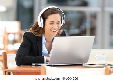 Portrait of a young executive girl watching video lecture on line sitting in a coffee shop
