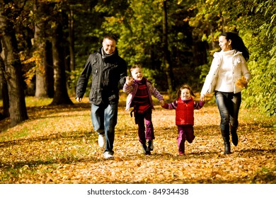 Portrait Of A Young Family In The Autumn Park