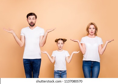 Portrait Of Young Family Bieng Confused, Bearded Father, Blonde Mother And Their Little Daughter Wearing Jeans And T-shirts, Showing Uncertain Gesture With Their Hands