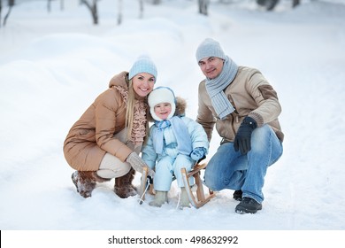 Portrait Of Young Family And His Baby In A Winter Park