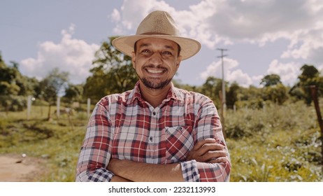 Portrait of young farmer man with crossing hands in the casual shirt and hat in the farm - Powered by Shutterstock