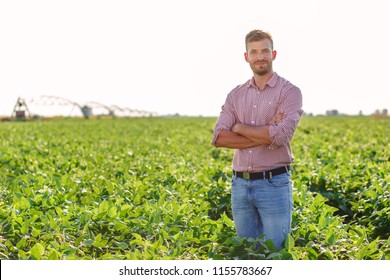 Portrait Of Young Farmer Standing In Soybean Field.