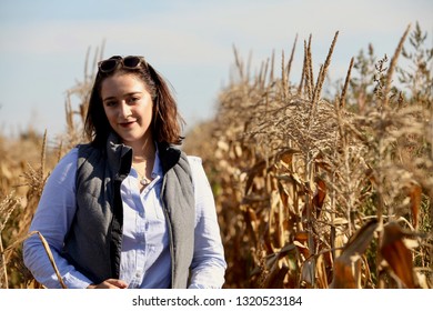 Portrait Of A Young Farmer Woman Smiling In Front Of Rows Of Wheat