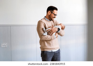 Portrait of young father holding his newborn baby. Fatherhood love single dad fathers day concept.