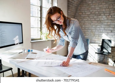 Portrait of young female architect working on project