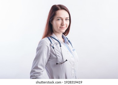 Portrait of a young female doctor in a white uniform in the studio on a white background